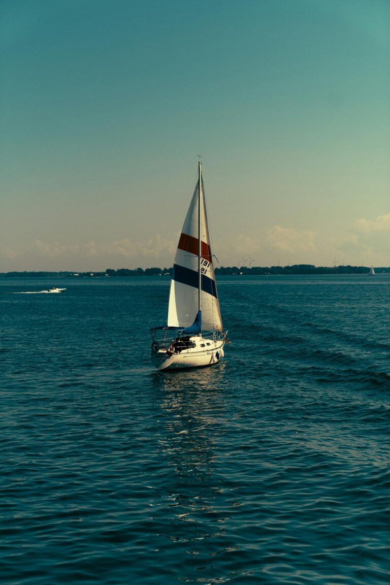 A serene sailboat drifts on the blue waters of the Saint Lawrence River, Québec City.