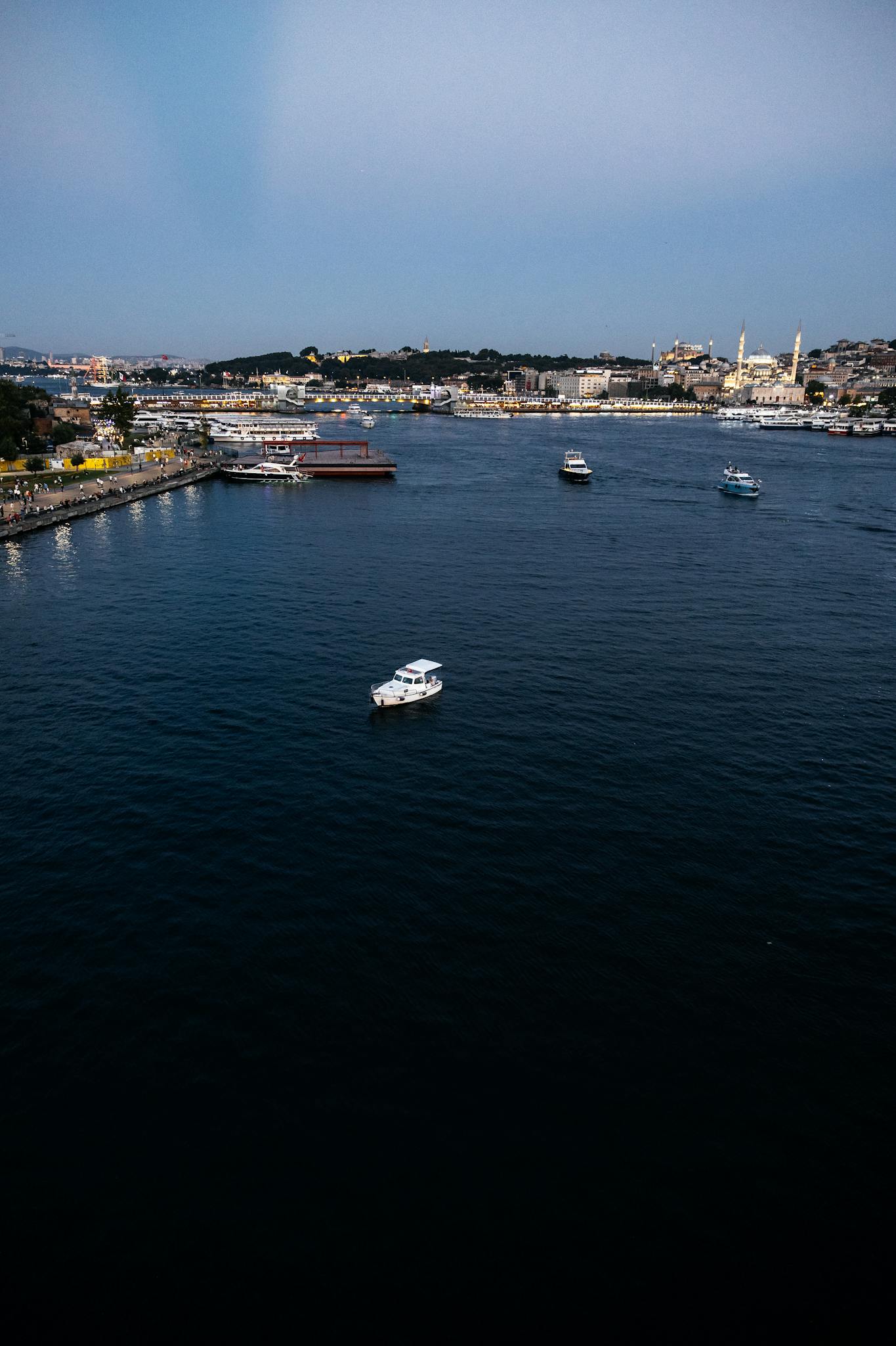 Aerial view of boats on the Bosphorus Strait with Istanbul cityscape in the background.