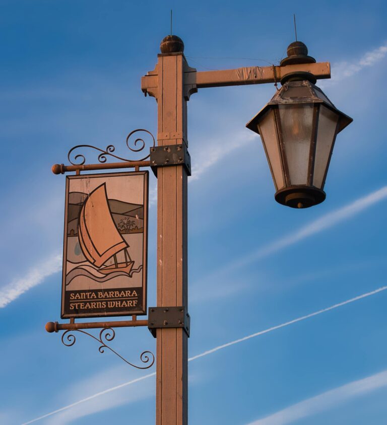 Street lamp and Stearns Wharf sign against a clear blue sky in Santa Barbara, California.