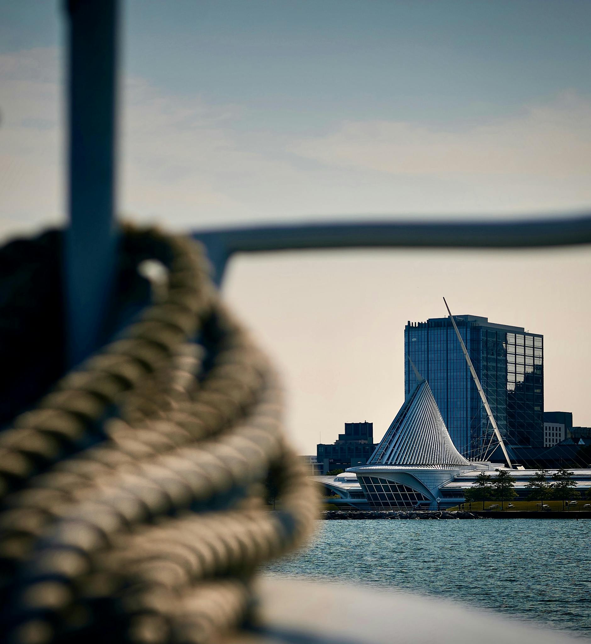 View of Milwaukee Art Museum with foreground focus on boat's rope, blending architecture and maritime vibes.